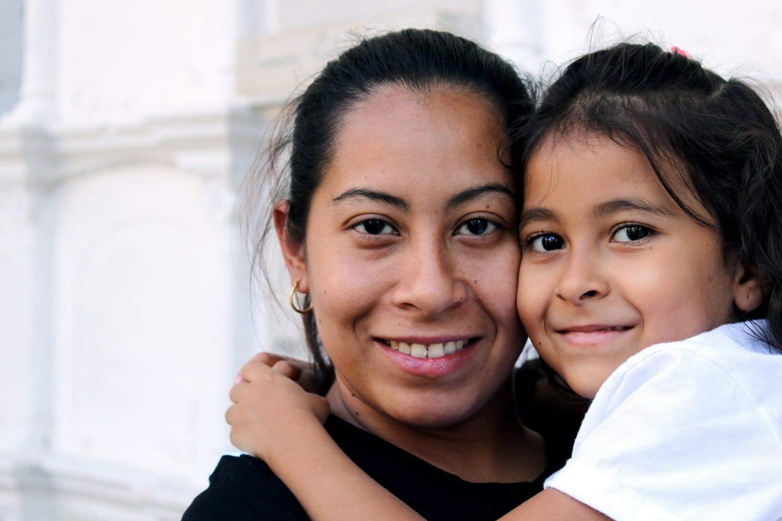 A mother and daughter smiling cheek to cheek