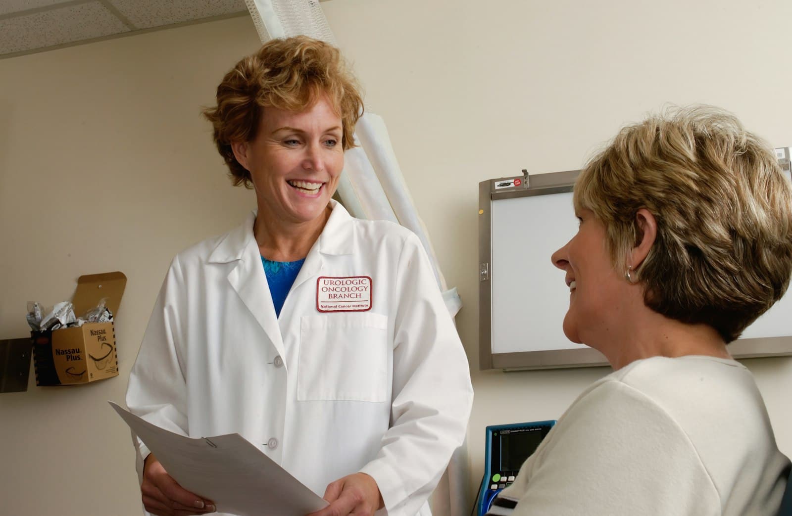 A smiling pharmacist talking with a patient