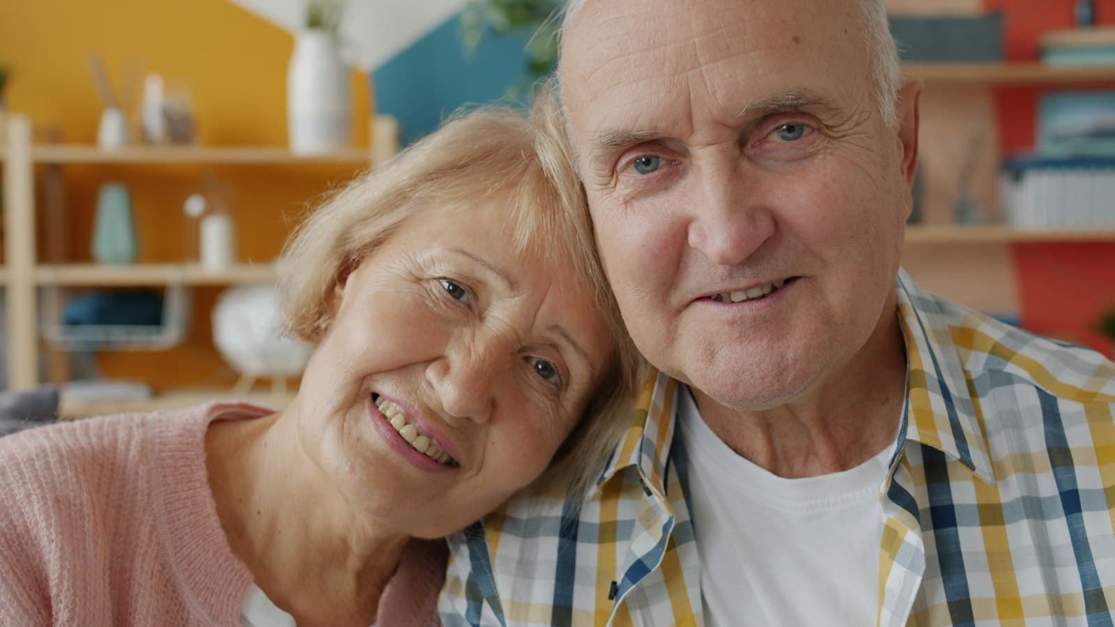An older couple smiling together at home